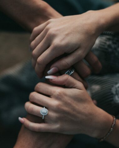 A woman wearing an engagement ring with her hands over a man’s; How to propose to a man.